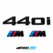 Gloss black BMW 440i rear lettering and two M wing badges with blue and red stripes.