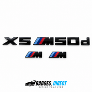 Gloss black BMW X5 M50d rear lettering and two smaller M wing badges with blue and red stripes.